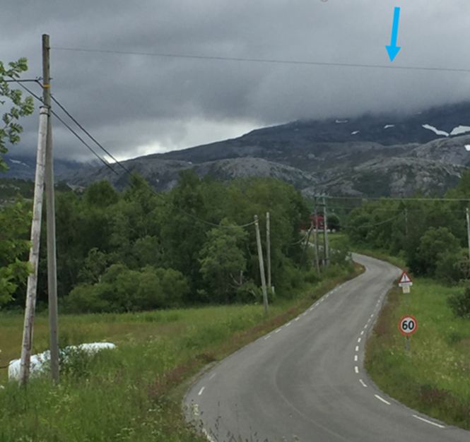 Strømførende ledning som henger fra påle til påle over vei.